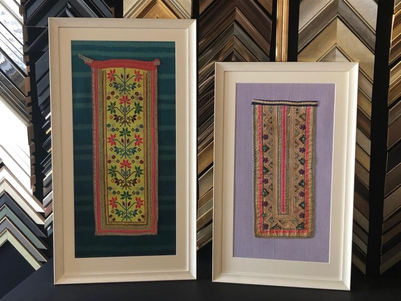 South East Asian textiles, stretched and framed with a white scooped moulding, mounted and glazed with Tru Vue reflection control glass.