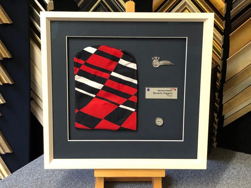 An ex-flight attendants scarf and badges framed with a Matt white box frame, mounted and glazed with Tru Vue reflection control glass.